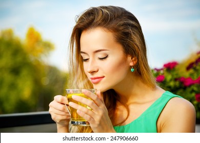 Young Woman Drinking Green Tea Outdoors. Summer Background. Shallow Depth Of Field.