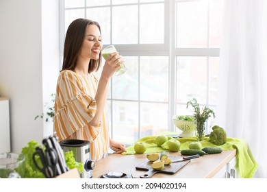 Young woman drinking healthy green smoothie in kitchen - Powered by Shutterstock