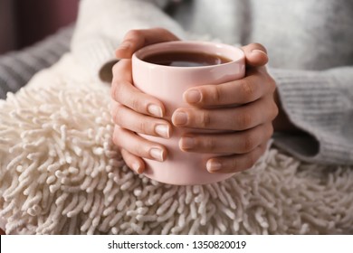 Young woman drinking hot tea at home, closeup - Shutterstock ID 1350820019