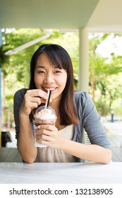 Young Woman Drinking Ice Coffee At Restaurant