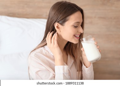 Young Woman Drinking Milk In Bedroom