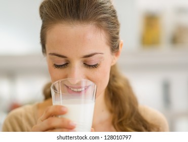 Young Woman Drinking Milk In Kitchen