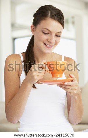 Young Woman Drinking Out Of An Orange Cup