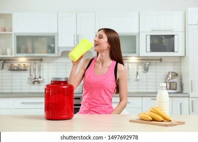 Young Woman Drinking Protein Shake In Kitchen