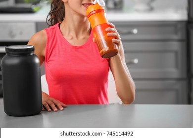 Young Woman Drinking Protein Shake In Kitchen