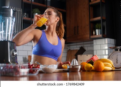 Young woman drinking smoothie and rerlaxing after running