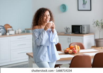 Young Woman Drinking Tasty Yogurt In Kitchen