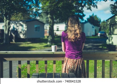 A Young Woman Is Drinking Tea Or Coffee In A Trailer Park