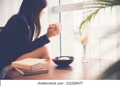 Young Woman Drinking Tea And Looking Out Of The Window