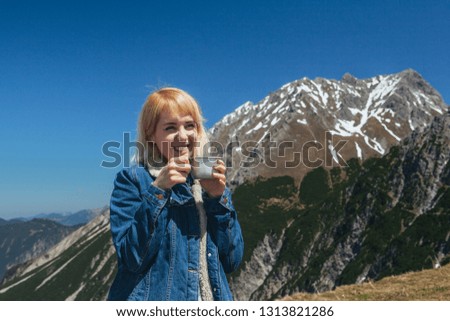 Young woman drinking tea at mountaintop