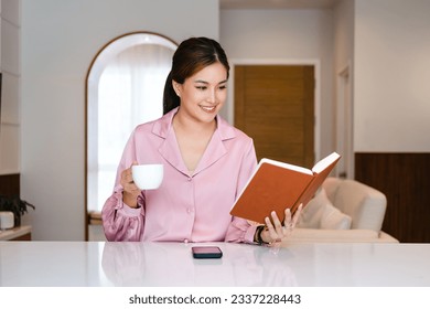 Young woman drinking tea and reading book in her kitchen while enjoying morning at home.

Asian woman reading book and drinking coffee at home. Morning lifestyle concept. - Powered by Shutterstock