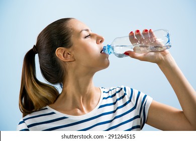 Young woman drinking water after jogging