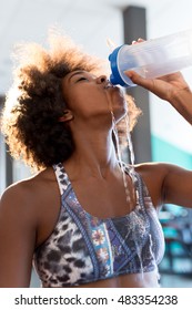 Young woman drinking water after training in gym - Shutterstock ID 483354238