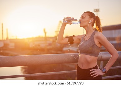 Young Woman Drinking Water After Running