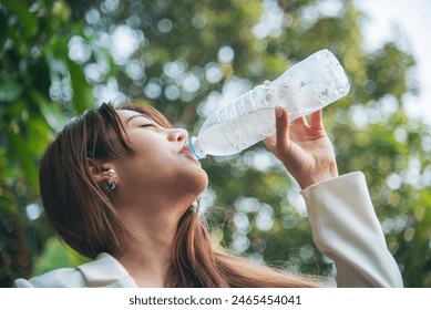 Young Woman Drinking Water bottle outdoor park traveler. Asian female drinking water bottle healthy person happy smile. Happiness Beautiful asian chinese women holding mineral water bottle lifestyle - Powered by Shutterstock