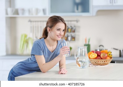 Young Woman Drinking Water From Glass In The Kitchen