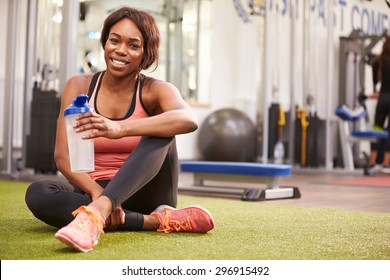 Young woman drinking water in a gym, with copy space - Powered by Shutterstock