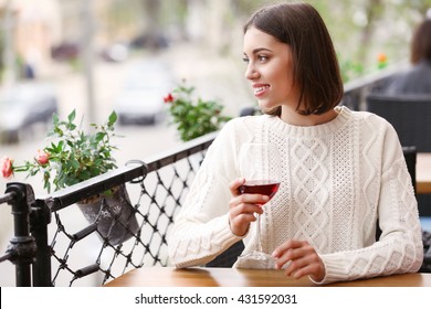 Young Woman Drinking Wine In Cafe