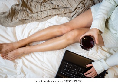 Young Woman Drinking Wine At Home In Her Bed And Checking Her Laptop Or Watching Movie, Top View, Flat Lay