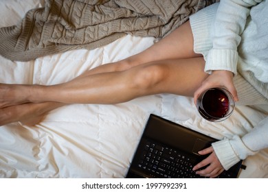 Young Woman Drinking Wine At Home In Her Bed And Checking Her Laptop Or Watching Movie, Top View, Flat Lay