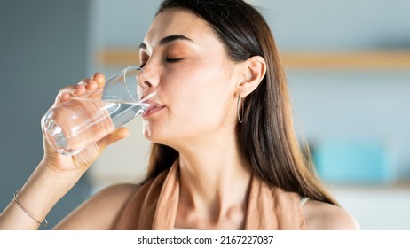 Young woman drinks a glass of water - Shutterstock ID 2167227087