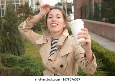 junge Frau trinkt Tee aus einem Glas auf der Straße