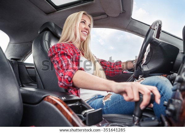 Young woman drive a car.\
Inside photo