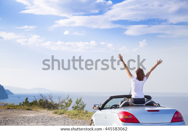 Young woman drive a car
on the beach.