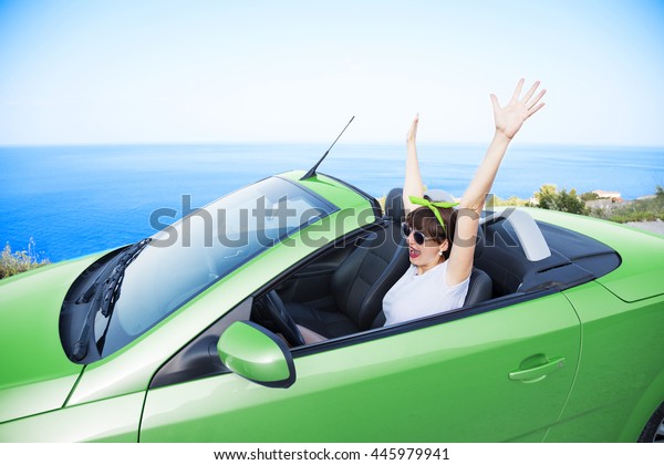 Young woman drive a car\
on the beach.