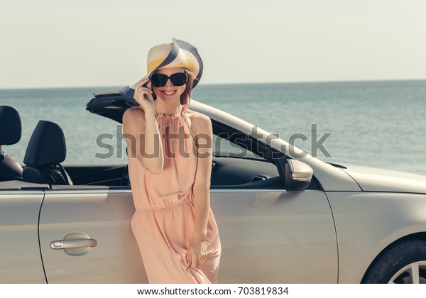 Young woman drive a car on\
the beach