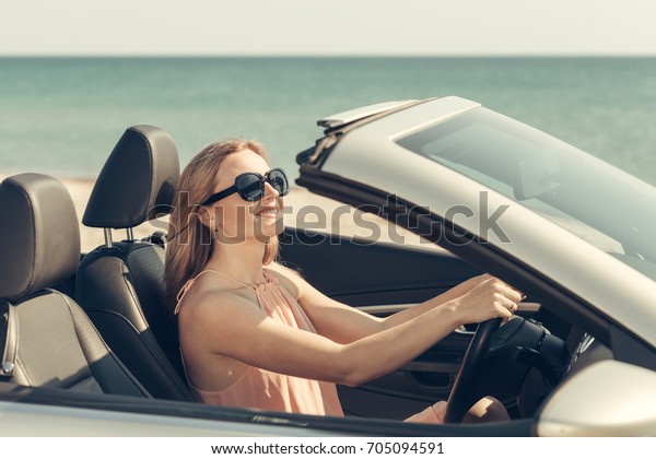 Young woman drive a car on
the beach