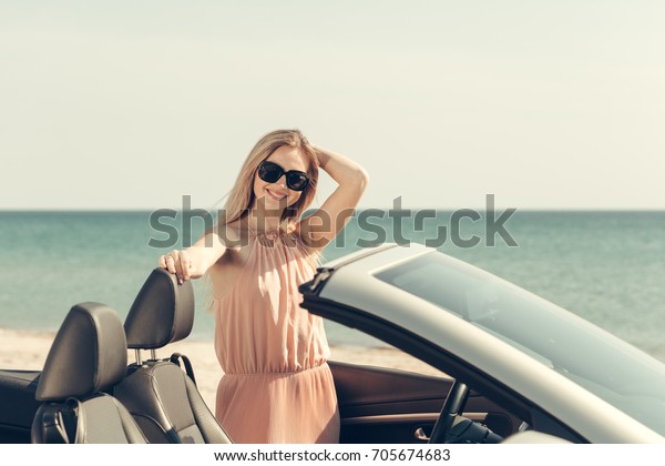 Young woman drive a car on\
the beach