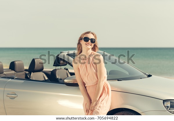 Young woman drive a car on
the beach