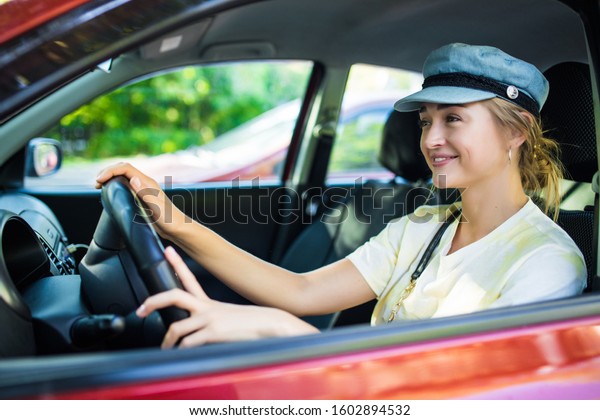 Young woman drive a\
new car in the street
