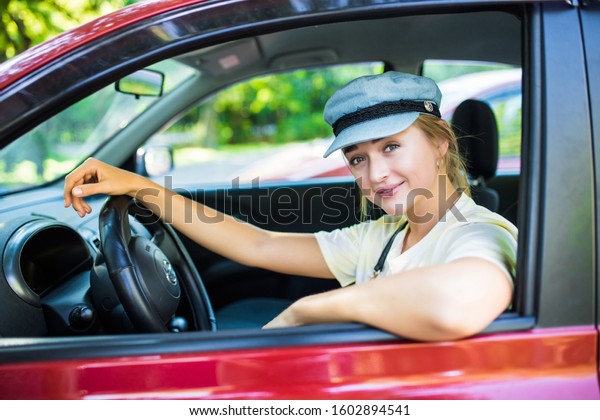 Young woman drive a\
new car in the street