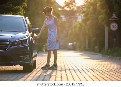 Young woman driver getting inside her car. Transportation and traffic concept.