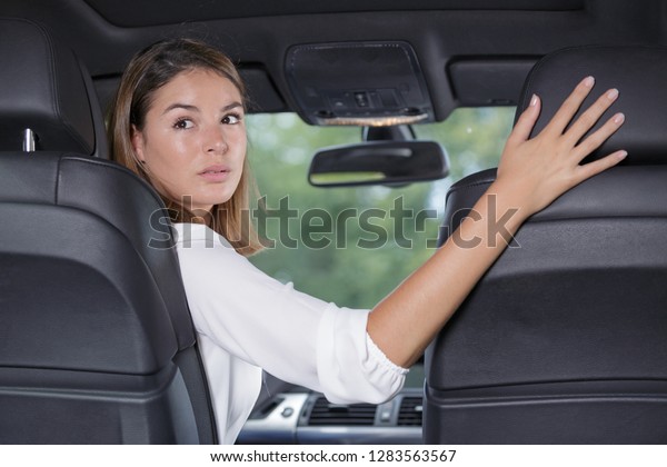 young woman driver reversing\
car