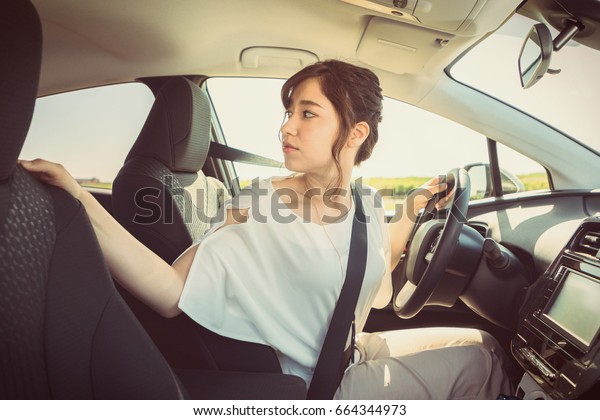 young woman driver turning
back.