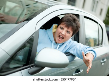 Young Woman Driver Yelling And Shaking Her Wrist Out Car Window.