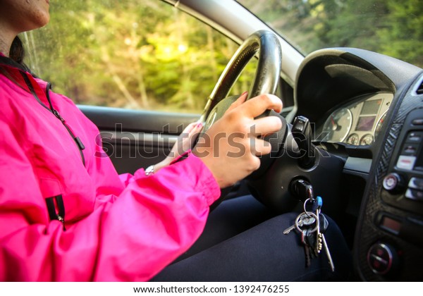 A young woman drives a modern car road that\
goes through the mountain.Concept.-relaxed drive after the city\
hustle.-Image