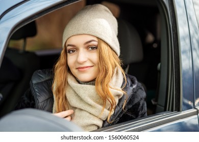 Young Woman Driving A Car. Beige Hat And Scarf. Concept Lifestyle, Autumn, Winter, Auto Driver.