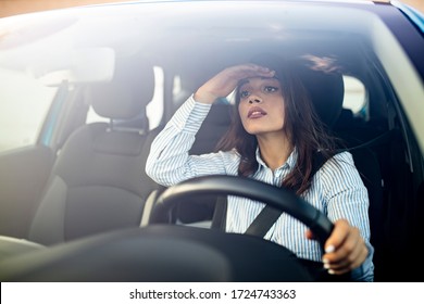 Young woman driving a car in the city. Portrait of a beautiful woman in a car, looking out of the window and smiling. Travel and vacations concepts. Close up of a businesswoman driving a car