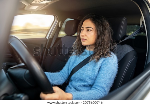 Young woman driving car on the road. Driver\
licence and driving safety\
concept.