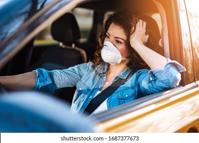 Young woman driving car with protective mask on her face.  Healthcare, virus protection, allergy protection concept. - Powered by Shutterstock