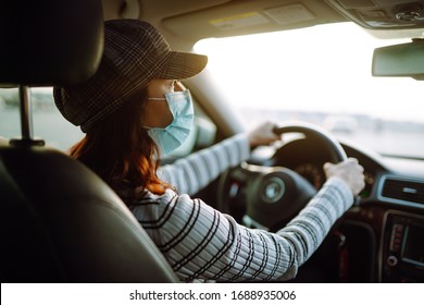 Young Woman Driving Car With Protective Mask On Her Face. The Concept Of Preventing The Spread Of The Epidemic And Treating Coronavirus, Pandemic In Quarantine City. Covid -19.