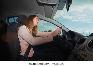 Young woman driving a small passenger car on sunny day