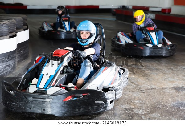 Young woman driving sport car for karting in a\
circuit lap in sport club