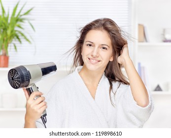 Young Woman Drying Hair At Home