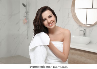 Young Woman Drying Hair With Towel In Bathroom