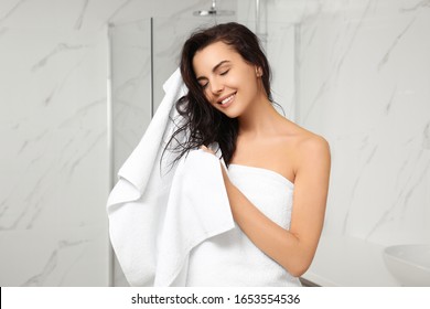 Young Woman Drying Hair With Towel In Bathroom